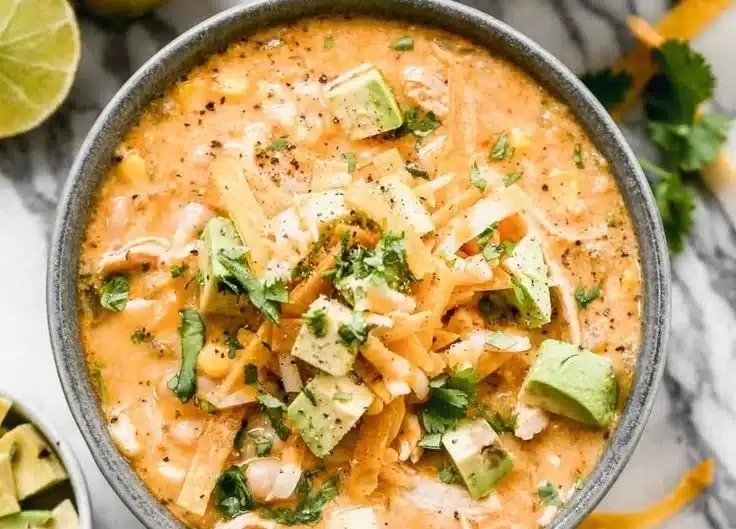 Bowl of award winning white chicken chili garnished with cilantro and jalapeños.