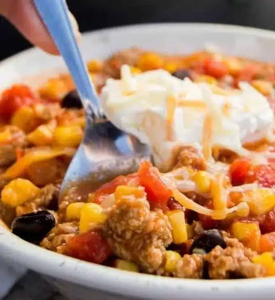 Home 6 A bowl of ground turkey taco soup garnished with cilantro and lime.