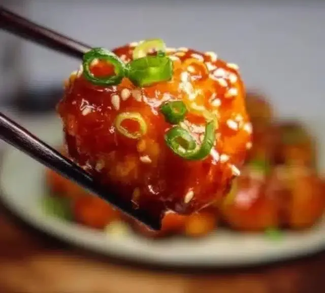 Plate of Honey Sesame Chicken garnished with sesame seeds and green onions