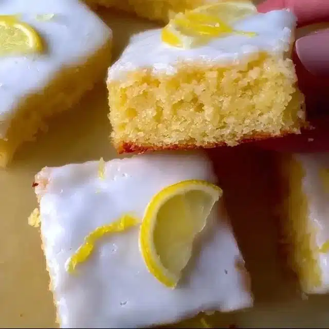 Delicious lemon brownies with a tangy frosting on a white plate