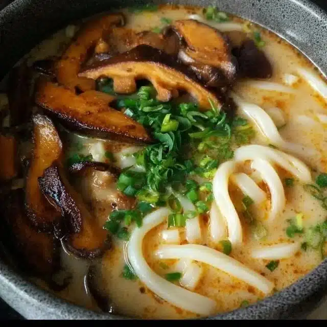 Home 1 Bowl of Miso Udon noodle soup with teriyaki mushrooms and fresh herbs