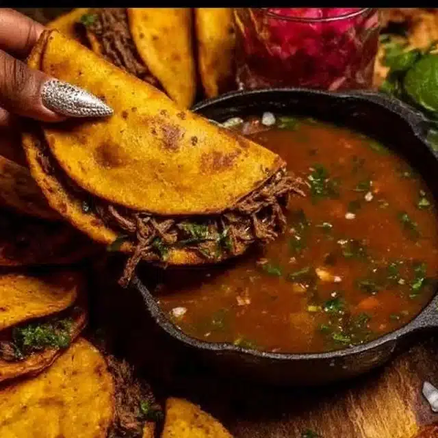 Delicious Ultimate Birria Tacos served with rich consomé and fresh toppings